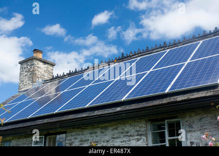 Solar panels on roof of traditional Welsh stone cottage Powys Mid Wales UK Stock Photo