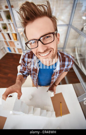 Happy young designer in making pyramid from cubes Stock Photo