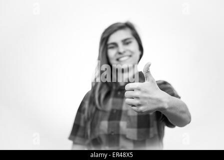 Teenage girl is showing thumbs up showing a nice, happy and supportive attitude. Stock Photo