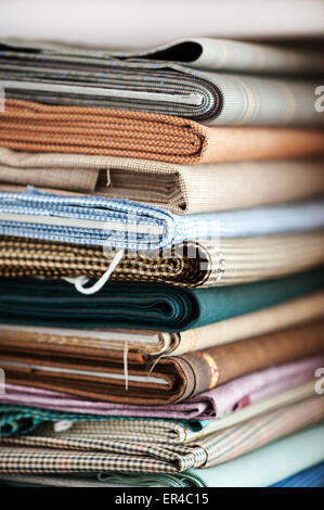 Close Up Detail of Stack of Folded Fabrics in Variety of Colors, Patterns, and Textures in Textile Shop Stock Photo