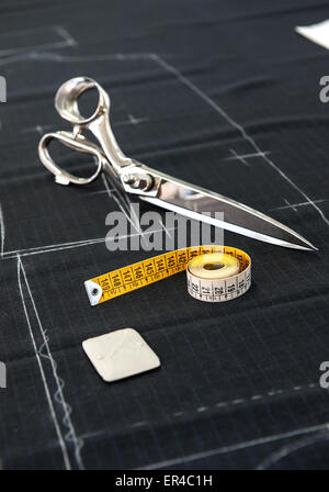 Still Life of Fabric Scissors and Tape Measure on Fabric Marked with Pattern in Clothing Design Studio Stock Photo