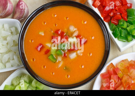 Spanish gazpacho decorated with olive oil drops and ingredients on bowls Stock Photo