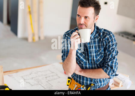 Candid construction worker relaxing with cup of coffee. Pilzno, Poland Stock Photo