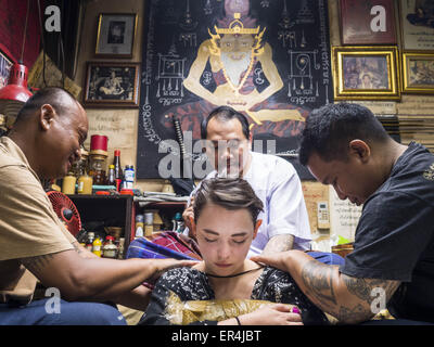 Bangkok, Bangkok, Thailand. 25th May, 2015. VANESSA, an American visitor to Thailand, gets a Sak Yant tattoo from AJARN NENG ONNUT. Sak Yant (Thai for ''tattoos of mystical drawings'' sak=tattoo, yantra=mystical drawing) tattoos are popular throughout Thailand, Cambodia, Laos and Myanmar. The tattoos are believed to impart magical powers to the people who have them. People get the tattoos to address specific needs. For example, a business person would get a tattoo to make his business successful, and a soldier would get a tattoo to help him in battle. The tattoos are blessed by monks or peopl Stock Photo