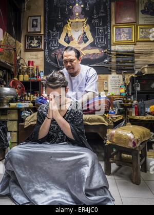 Bangkok, Bangkok, Thailand. 25th May, 2015. VANESSA, an American visitor to Thailand, gets a Sak Yant tattoo from AJARN NENG ONNUT. Sak Yant (Thai for ''tattoos of mystical drawings'' sak=tattoo, yantra=mystical drawing) tattoos are popular throughout Thailand, Cambodia, Laos and Myanmar. The tattoos are believed to impart magical powers to the people who have them. People get the tattoos to address specific needs. For example, a business person would get a tattoo to make his business successful, and a soldier would get a tattoo to help him in battle. The tattoos are blessed by monks or peopl Stock Photo