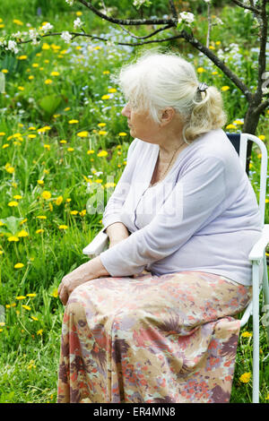 The grandmother in  garden under a blossoming apple-tree Stock Photo