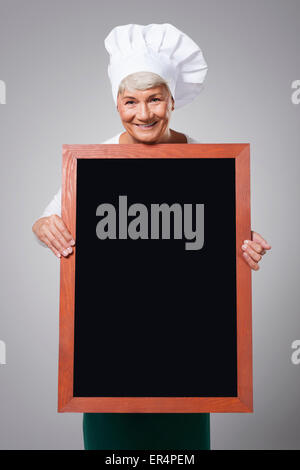 Female senior chef with menu. Debica, Poland Stock Photo