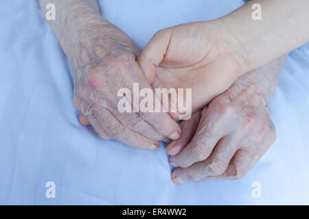 Old and young woman join hands together Stock Photo - Alamy