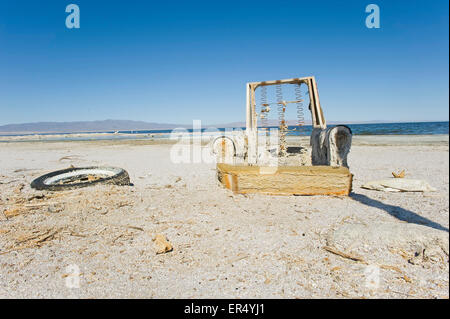 Abandoned chair and tire on the beach, Salton Sea Beach, Southern California USA Stock Photo