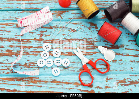 needle thread sewing tailor thimble buttons scissors repair background  blue wood  teak still life vintage color Stock Photo