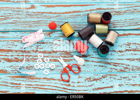 needle thread sewing tailor thimble buttons scissors repair background  blue wood  teak still life vintage color Stock Photo