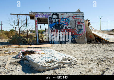 Abandoned shack covered in graffiti with mattress in foreground, Salton Sea Beach, Southern California USA Stock Photo