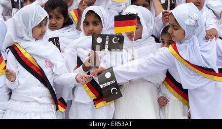 Hanau, Germany. 27th May, 2015. Young girls wearing German sashes and holding flags depicting the Islamic crescent wait for the arrival of the guests of honour during the opening of the new Bait-ul-Wahid mosque of the Ahmadiyya Muslim Jamad denomination in Hanau, Germany, 27 May 2015. The mosque has two 12-metres tall minarets and offers space for up to 500 people. Photo: BORIS ROESSLER/dpa/Alamy Live News Stock Photo