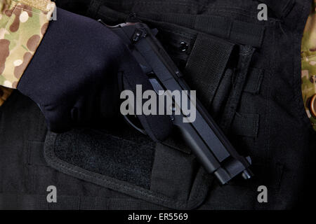 man in combat fatigues and bullet proof jacket  holding beretta semi automatic pistol Stock Photo