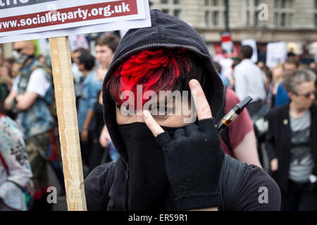 London, UK. 27th May, 2015. A demonstrator poses in central London during an evening of protest against public sector spending cuts imposed by Britain's Conservative Party in the years since the party, known also as the Tories, came to power in 2010. The evening's protests were held on the day of the State Opening of Parliament, with spending cuts set to continue—and, many fear, deepen—following the Conservatives' surprise majority win in Britain's recent general election. Credit:  David Cliff/Alamy Live News Stock Photo