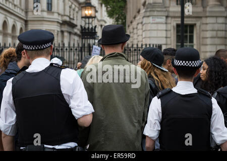 London, UK. 27th May, 2015. Demonstrators and police pictured outside Downing Street, central London, during an evening of protest against public sector spending cuts imposed by Britain's Conservative Party in the years since the party, known also as the Tories, came to power in 2010. The evening's protests were held on the day of the State Opening of Parliament, with spending cuts set to continue—and, many fear, deepen—following the Conservatives' surprise majority win in Britain's recent general election. Credit:  David Cliff/Alamy Live News Stock Photo