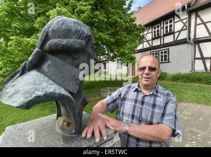 Molmerswende, Germany. 20th May, 2015. Erwin Moras of the Gottfried-August-Buerger friend's association poses in front of the derelict birthplace of the poet Gottfried August Buerger next to a bust of the poet in Molmerswende, Germany, 20 May 2015. Moras and other members of the association fight for the use of the house as a museum. Photo: Hendrik Schmidt/dpa/Alamy Live News Stock Photo