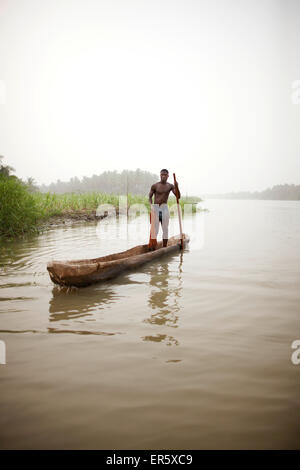 Man in a logboat fishing on Mono river, Agbanakin, near Grand-Popo, Mono Department, Benin Stock Photo