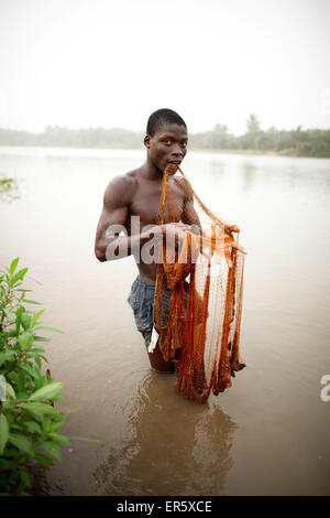Young man fishing with cast net in river Mono, Agbanakin, near Grand-Popo, Mono Department, Benin Stock Photo