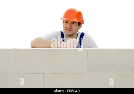 Builder erects a wall from a brick Stock Photo