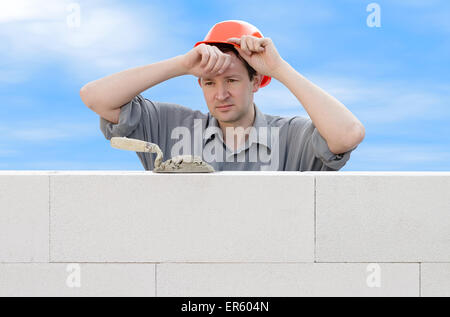 Construction worker wiping the sweat from his forehead Stock Photo