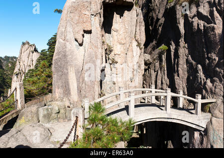 Small arch bridge spanning deep canyon of granite rocks, Mount Huangshan, Huang Shan, Anhui Province, China Stock Photo