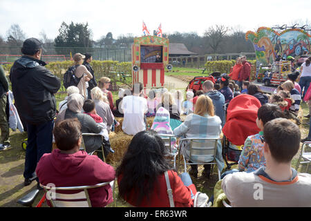 Families watch a traditional Punch and Judy show in a London Park Stock Photo