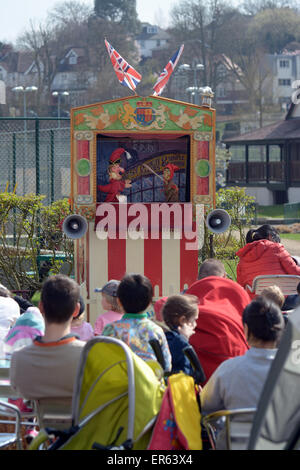Families watch a traditional Punch and Judy show in a London Park Stock Photo