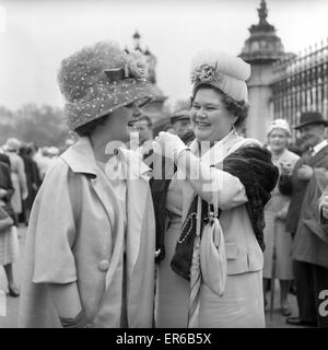 Buckingham Palace Garden Party: Visitors and passers by outside Buckingham Palace had a freed hat fashion show today. Frills and fancies, flowers and Tulle, and bits and pieces made up the hats large and small, tall and wide, as the women guests followed Stock Photo