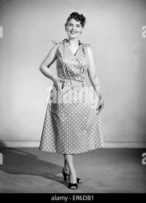 Clothing: Fashion: Beachwear: Woman wearing beach wrap and dress. Model: Audrey Hurst. 1955 B472-005 Stock Photo