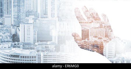 Double exposure conceptual collage with a male hand and modern big city background Stock Photo