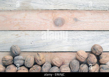 Some nuts scattered on a sack on a rustic wooden kitchen, background Stock Photo