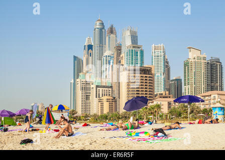 Sunbathers on the Public Dubai Beach at JBR (Jumeirah Beach Resort) , Dubai, United Arab Emirates, UAE, Middle east Stock Photo