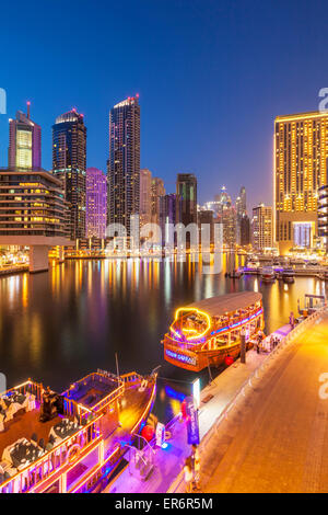 Dubai Marina Skyline and tourist boats at night Dubai City United Arab Emirates UAE Middle east