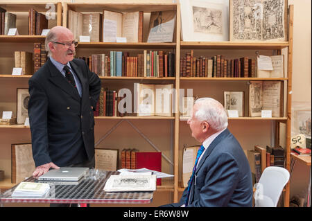 London, UK. 28 May 2015. Buyer meets client, as literary fans and collectors gather for the 58th London International Antiquarian Book Fair at Kensington Olympia. This major three-day event is one of the largest and most prestigious antiquarian book fairs in the world, showcasing rare, unique and unusual items from 180 leading UK and international dealers. Credit:  Stephen Chung / Alamy Live News Stock Photo