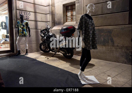 Clothed mannequins and motorcycle in alley in Barcelona at night Stock Photo