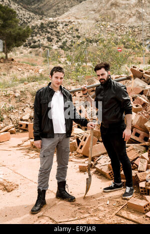 Two guys with tools amidst rubble on a demolition site Stock Photo