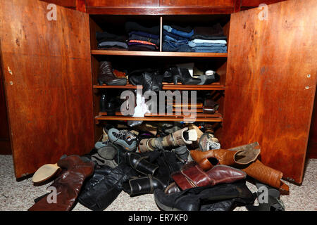 Selection of womens shoes scattered untidily on floor in front of wardrobe in bedroom Stock Photo