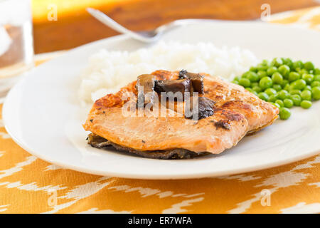 Crispy grilled salmon fillet with roasted portobello mushrooms and sweet glaze with peas and rice on the side Stock Photo