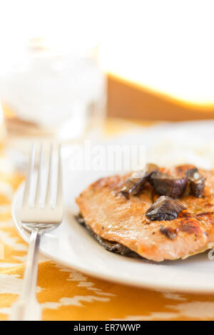 Crispy grilled salmon fillet with roasted portobello mushrooms and sweet glaze with peas and rice on the side Stock Photo