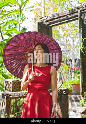 Woman in red dress at traditional Thai House