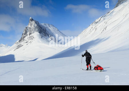 Woman with pulka cross-country skiing in Swedish Lapland Stock Photo