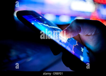 A city businessman using a mobile device to check stocks and market data. Close up shot. Stock Photo