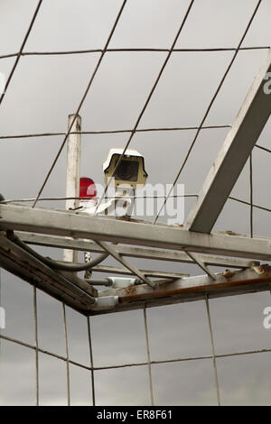 Low angle view of surveillance camera attached on metal roof Stock Photo