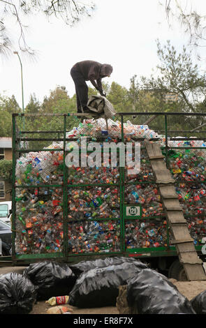 Man working on heap of recyclable plastic waste at garbage dump Stock Photo