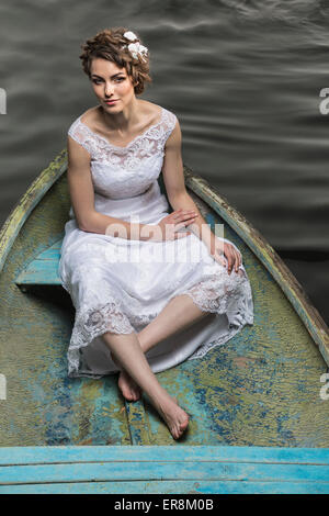 High angle portrait of young bride sitting in boat on lake Stock Photo