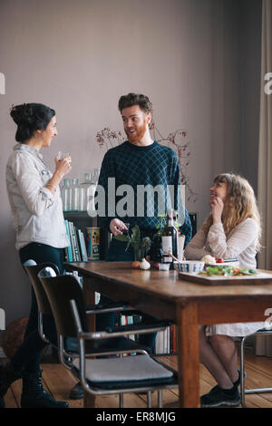 Young man with female friends having breakfast at home Stock Photo