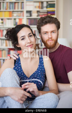 Portrait of young woman with man relaxing at home Stock Photo