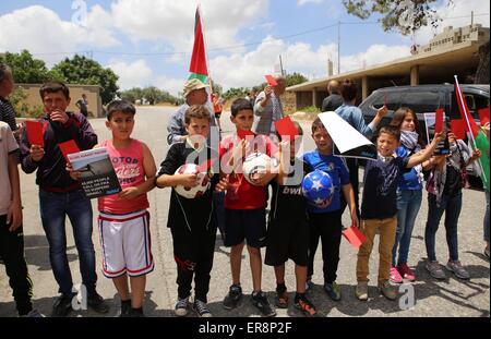 Ramallah, West Bank, Palestine. 29th May, 2015. Palestinian children hold red cards in front of Israeli security forces during a demonstration against the Israeli Football Federation, in the West Bank village of Nabi Saleh, near Ramallah, 29 May 2015. The Palestinian Football Federation is launching a campaign for the suspension of Israel's membership in FIFA, ahead of voting during the FIFA Congress in Lausanne, Switzerland. Credit:  ZUMA Press, Inc./Alamy Live News Stock Photo