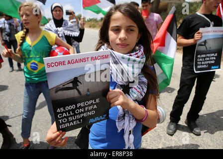 Ramallah, West Bank, Palestine. 29th May, 2015. Palestinian activists hold banners and red cards in front of Israeli security forces during a demonstration against the Israeli Football Federation, in the West Bank village of Nabi Saleh, near Ramallah, 29 May 2015. The Palestinian Football Federation is launching a campaign for the suspension of Israel's membership in FIFA, ahead of voting during the FIFA Congress in Lausanne, Switzerland. Credit:  ZUMA Press, Inc./Alamy Live News Stock Photo